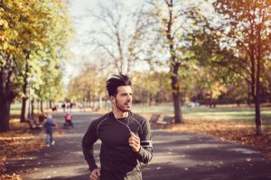Sportsman jogging in the autumn park